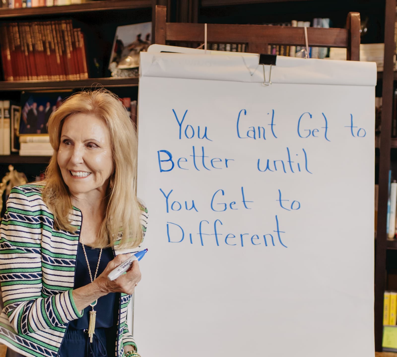 Dianna Kokoszka at a flip chart, writing the words “You Can’t Get to Better until You Get to Different” in marker.