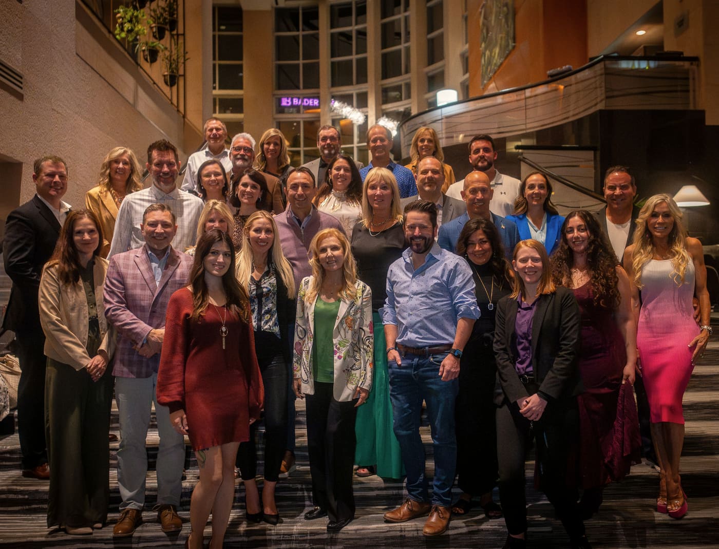 A group of about thirty readers gathered on a hotel lobby staircase, Dianna Kokoszka standing at the centre of the front row